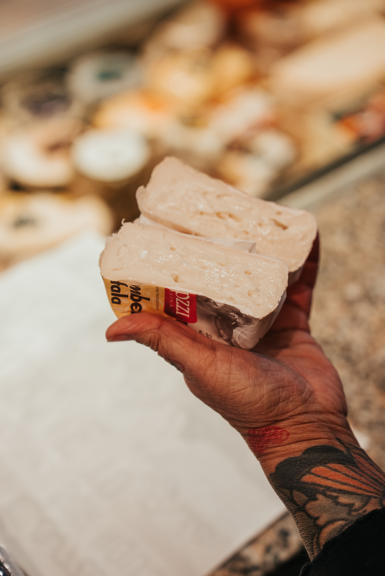 Mozzarella di bufala Mozzi tenue en main devant le comptoir Cheese'Op